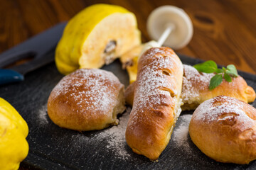 Pastries. Sweet buns with quince and honey filling, on a wooden table