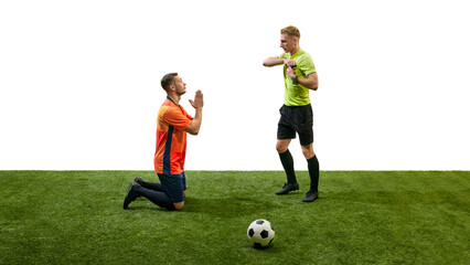 Obraz premium Man, soccer player in orange uniform standing on knees and holding hands in praying gesture towards referee ready to show card. Concept of sport, fair play, competition, control, rules