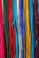 Thin, colorful leather strips arranged as a decorative background for braiding and crafting