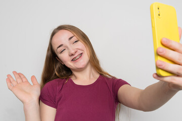 Young beautiful girl uses modern smartphone at home