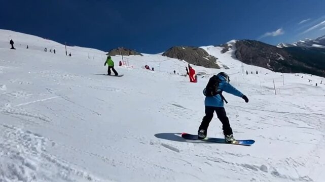 Group of snowboarders slides down ski slope. Snowboarders have fun and fervently go down snowy track together. Company of active friends like-minded people love and interested in hobby of snowboarding