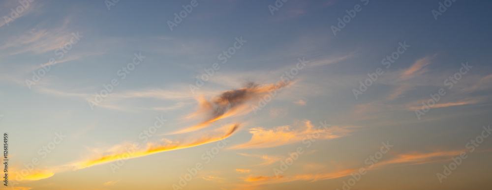 Wall mural sunset sky background in the evening with clouds and colorful orange sunlight on twilight sky.