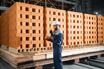 Worker man carries out quality control of bricks at a ceramics factory