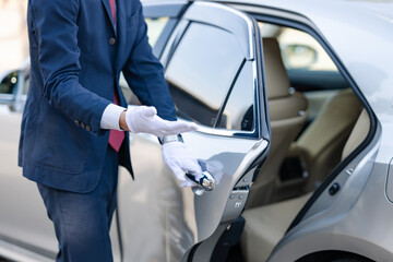 車の後部ドアを開ける運転手