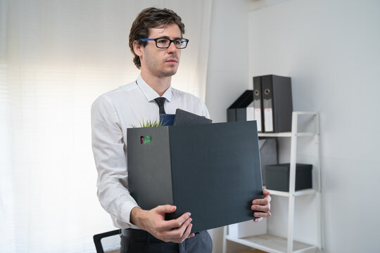 lay off workers. Banner size closes up hands of usinessman holding box of stuff to leave office after fired from work.