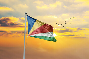 Waving flag of Seychelles against sunset or sunrise. Seychelles flag for Republic Day and Independence Day.
