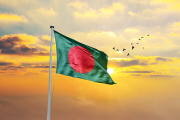 Waving flag of Bangladesh against sunset or sunrise. Bangladesh flag for Republic Day and...