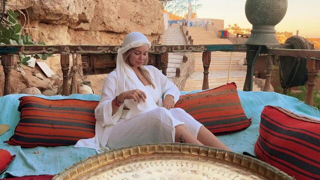 A beautiful girl in traditional clothes rests in a cafe in Egypt