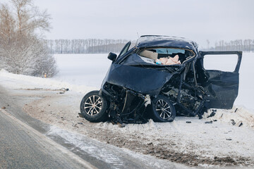 Crashed car in accident Head-on collision on winter road with snow