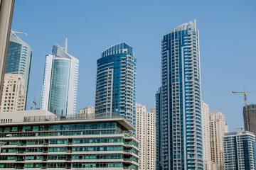 Fototapeta premium High-rise buildings with glass facade against blue sky. Business center. View from below