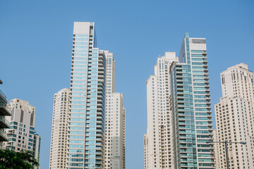 Fototapeta premium High-rise buildings with glass facade against blue sky. Business center. View from below