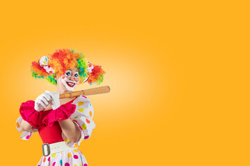 Funny female clown club-swinging. Entertainer woman Joker in colorful suit and wig. Buffoon with...