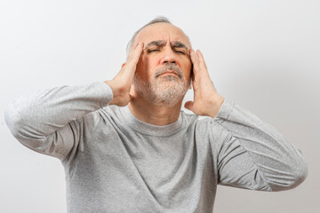 Mature man clutching his head with his hands. Older man suffers from headache, forgetfulness,...