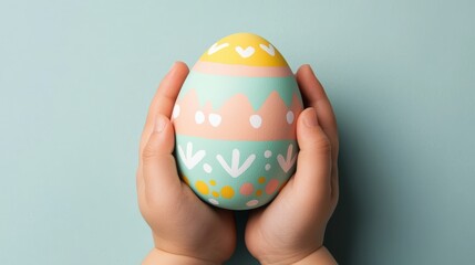 Child's joyful hands grasping a decorated easter egg closeup