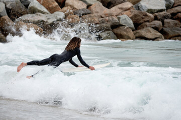 Side view of surfer carrying surfboard