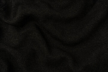 Dark grey sweater texture as a background. Knitted pattern.