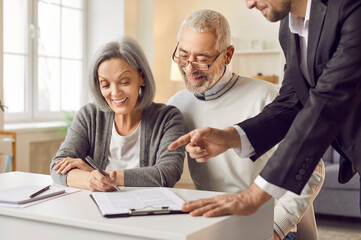 Obraz premium Senior couple happy filling document at appointment in lawyer office, agent helping to sign medical treatment contract, insurance agreement, medic care paperwork to sign agreement, legal support