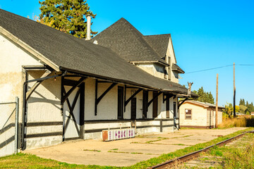 A train station with a large building and a fence