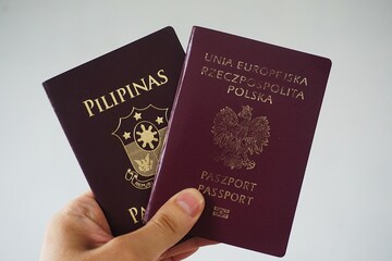 Paszport Rzeczpospolita Polska i paszport Filipiński. Dwa paszporty trzymane w dłoni.