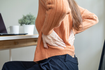 office syndrome, woman with back pain symptoms during work in the office.