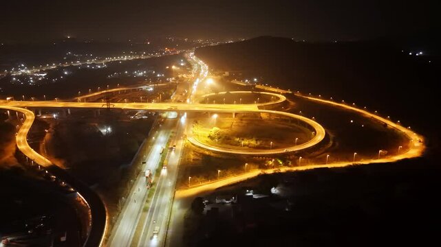 Nighttime aerial of intertwined bridges glowing