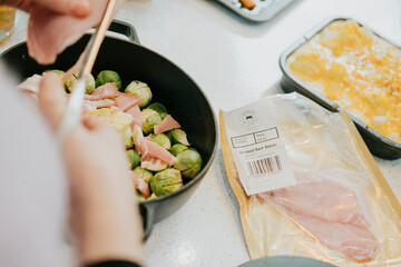 A person is cooking food in a pan with a bag of chicken on the counter. The chicken is labeled with a number of 3