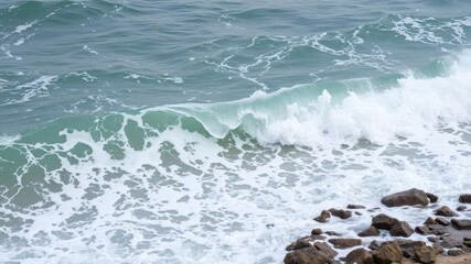 Fototapeta premium Powerful ocean wave crashing on rocky shore, causing a splash of foamy seawater, crashing, foamy