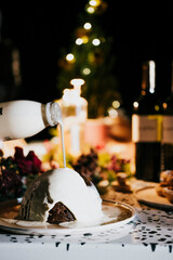 A bottle of milk is poured into a dessert. The dessert is a cake with a hole in the middle. The cake is sitting on a plate on a table