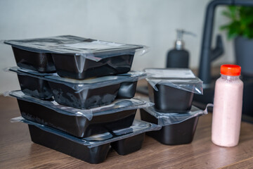 Black boxes with healthy diet plan for weight loss, delivery of daily ready meal menu. Food ordered with mobile phone app. Balanced portion with dish. Pre-cooking.