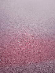 Frozen red surface covered with sparkling ice crystals in winter