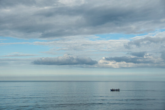 Distant view of five people in a rowing boat at sea, St Andrews, Fife, Scotland, UK