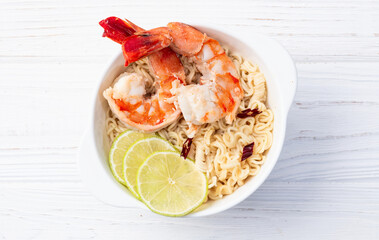 Tom yum soup with shrimps instant noodles and lime photography . Asian food . Top view