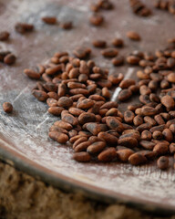 A woman in Oaxaca Mexico roasting cocoa beans on a comal in a wood-burning stove.