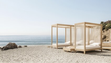 Fototapeta premium Beachside cabanas on a sandy shore with a calm ocean backdrop.