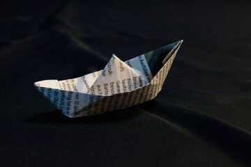 Simple Origami Boat Made From Newspaper On Dark Background