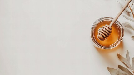 Fototapeta premium A glass jar filled with golden honey, a wooden honey dipper resting inside, set on a pristine white background for natural food themes 