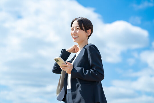 ビジネス女性・スマホ・青空