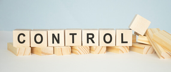 Control word wooden cubes on yellow background.