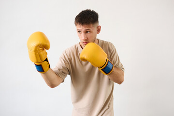 Handsome young guy shows defense technique with boxing gloves