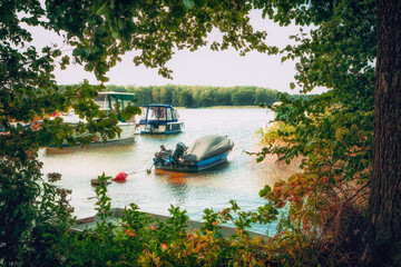 Fototapeta premium Old boat on water and in a meadow. Rotted and rusted, hardly usable anymore. Damaged boat in idyllic solitude.