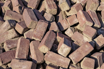 Close-up of a pile of old Dutch red rectangular street bricks that can be reused. 