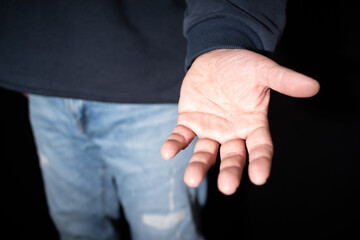 A man has his arm extended towards in an open gesture of giving or help.A helping hand. Giving a...