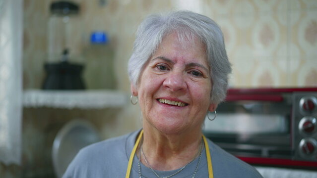 Close-up of a happy elderly woman with gray hair. Senior person in 70s smiling at camera