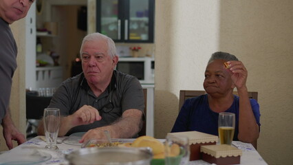 Candid senior friends gathered for lunch. authentic elderly people seated for meal