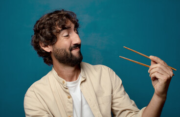 young adult bearded man with chopsticks