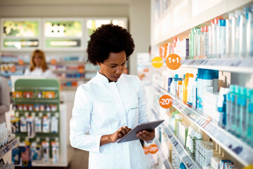 Pharmacist using tablet for inventory in pharmacy store