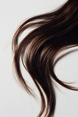 Flowing long curly strand of hair, isolated on white background