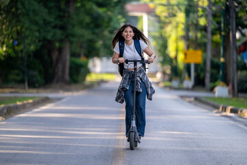 A woman is riding a scooter down a street