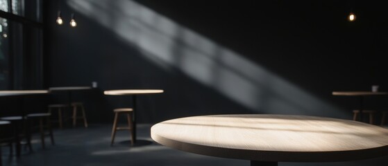 Obraz premium Dimly lit room with a round wooden table in the center. the table is made of light-colored wood and has a smooth surface.