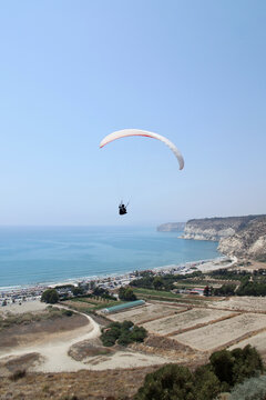 Flying paraglider in the sky,  Kourion, Cyprus, vertical picture